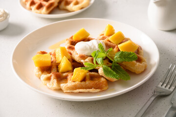 Popular croffles with maple syrup and whipped cream for delicious breakfast. Croissant as waffle. Korean cuisine.