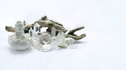 Clear quartz minerals and Buddha statue on light marble background. gemstones for healing Magic...