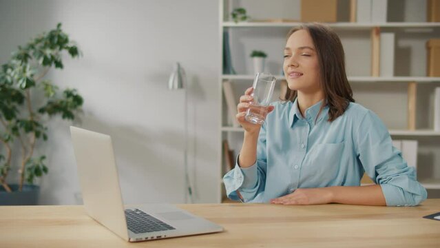 Female Office Worker Drink a Glass of Clean Water During a Break Between Work. Take Break Drink Natural Mineral Water Makes Sip Caring About Health, Prevents Dehydration. Everyday Routine Concept.