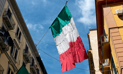 bandiera italiana che sventola alo vento in un vicolo