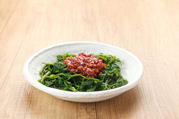 Plecing Kangkung or Brambang Asem, made from boiled spinach served with chili sauce (sambal), spicy and sour. Indonesian food
