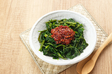 Plecing Kangkung or Brambang Asem, made from boiled spinach served with chili sauce (sambal), spicy and sour. Indonesian food
