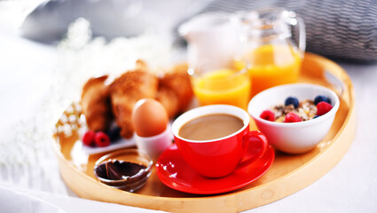 A tray with breakfast on a bed in a hotel room
