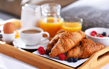 A tray with breakfast on a bed in a hotel room