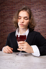 Young attractive guy drinks wine. Gifts and holidays.