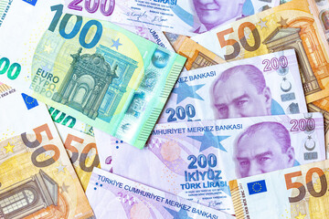 Group of money EURO and Turkish Lira banknote arranged in a chaotic manner. EURO and Turkish banknote isolated on pink background. Exchange money, Cash, Travel concept, Money background ,Currency.