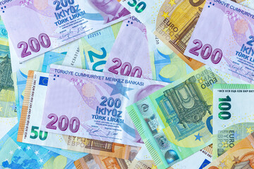 Group of money EURO and Turkish Lira banknote arranged in a chaotic manner. EURO and Turkish banknote isolated on pink background. Exchange money, Cash, Travel concept, Money background ,Currency.