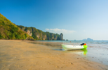 Fototapeta na wymiar kayak boat on sand beach and clear sea blue sky to people or person and tourists playing kayaking in water with mountain for summer holiday travel and vacation recreation at ao nang krabi in thailand