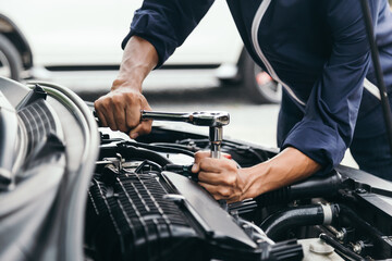 Fototapeta na wymiar Automobile mechanic repairman hands repairing a car engine automotive workshop with a wrench, car service and maintenance,Repair service.