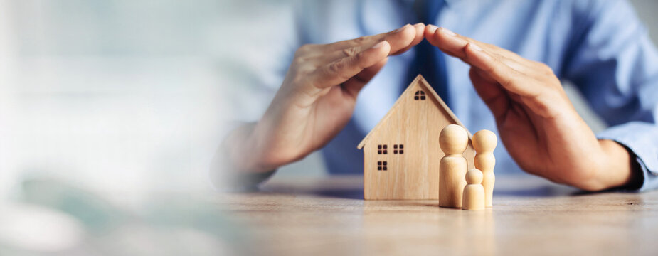 Insurance house, and family health live concept. The insurance agent presents  the ้hands protection model that symbolize the coverage.