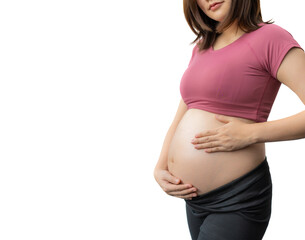 Close up of the happy pregnant woman in fitness clothes standing happily holding her exposed belly