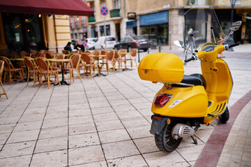 Motorbike outdoor. Yellow retro style scooter on the town street.