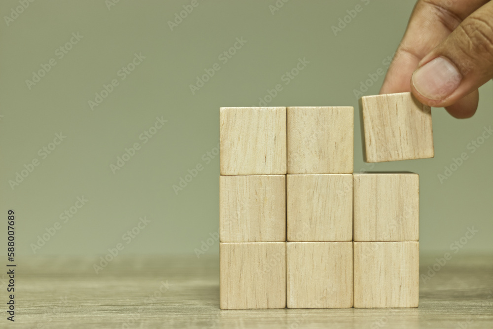 Poster Hand stacking blank wooden cubes on table for input wording and infographic icon.