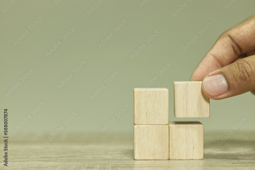 Poster hand stacking blank wooden cubes on table for input wording and infographic icon.