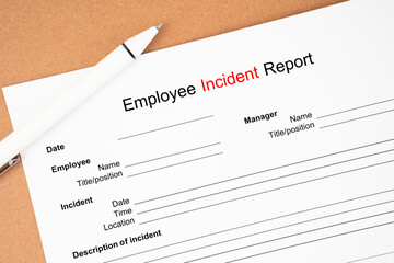 The Template of an Employee incident report form document and and pen on wooden background.