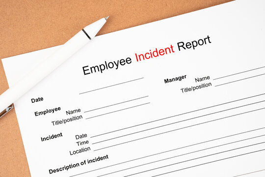 The Template of an Employee incident report form document and and pen on wooden background.