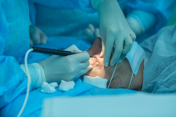 a  woman ophthalmologist performs an operation on the patient's eye