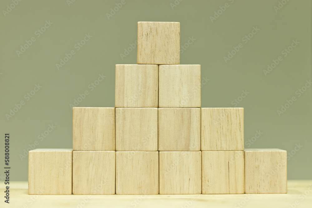 Poster blank wooden cubes arranged in pyramid shape on table for input wording and infographic icon.