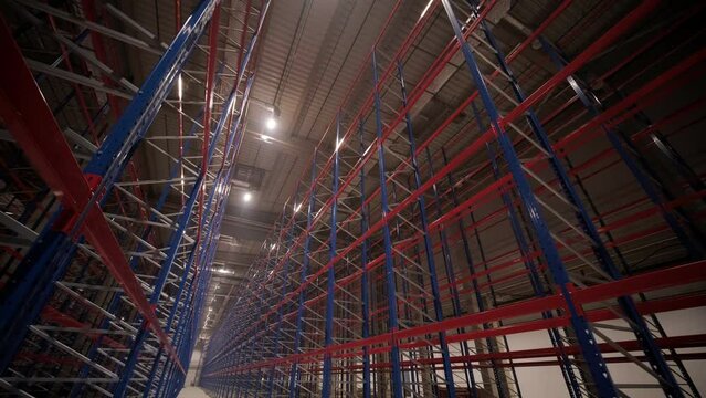 Big and modern warehouse under construction, featuring metal shelving and other industrial equipment.