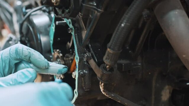 Close up, oiling False neutral eliminator kit on the motorcycle transmission box. High quality 4k footage