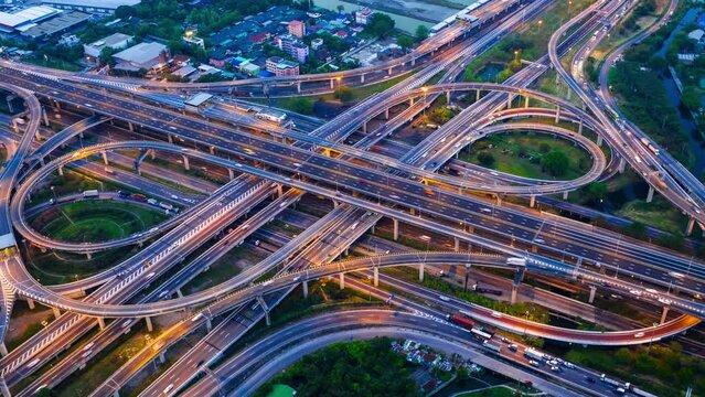 Aerial hyperlapse of traffic on massive highway intersection at night.