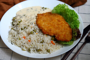Rice with vegetables and chicken schnitzel. Healthy lunch or dinner on a plate.