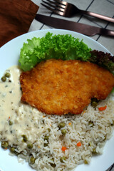 Rice with vegetables and chicken schnitzel. Healthy lunch or dinner on a plate.