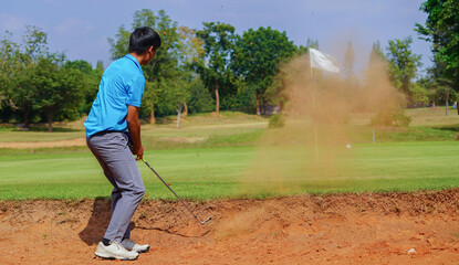 Obraz premium golfer hits a ball off a sand bunker, the hurdles of the golf course.