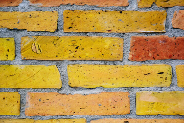 textured light brown and yellow brick wall closeup. gray mortar joint. rough clay texture. running bond pattern. construction industry and architecture concept. wallpaper and graphic resources