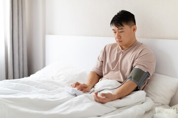 Middle aged asian man doing morning checkup after waking up