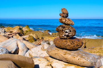 Wave-worn rocks stacked in front of crashing waves