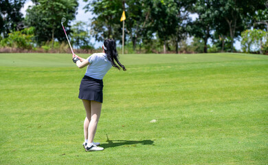 Professional woman golfer teeing golf in golf tournament competition at golf course for winner	