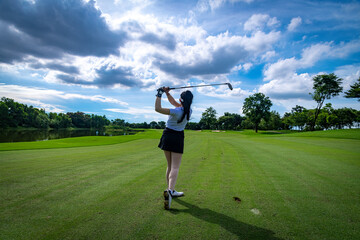 Professional woman golfer teeing golf in golf tournament competition at golf course for winner	