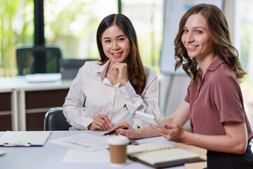 Concept of business office woman working,ฺ Businesswoman working with investment plan with her partner and analyzing document business investment graph data by using calculator and laptop