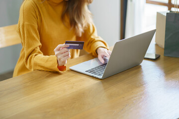 Woman shopping on laptop holding credit card for Internet online e-commerce shopping spending money Online shopping Mobile phone laptop technology concept