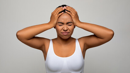 Upset african american woman suffering from terrible strong head pain