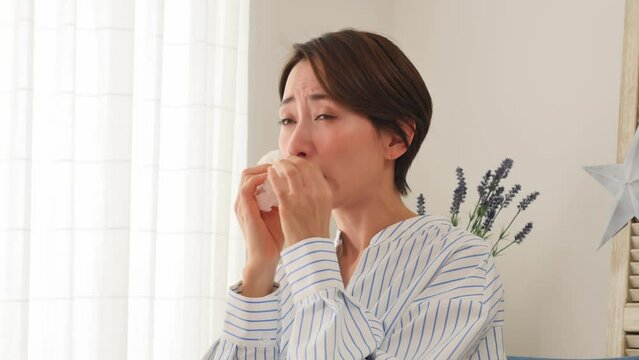 リビングで鼻炎に悩む女性