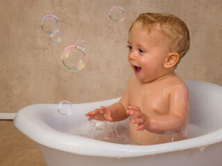 Blonde baby boy meets a soap bubble