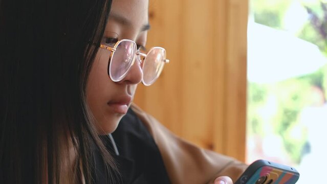 Asian girl in eyeglasses are addictive playing mobile phones, Game Addiction	