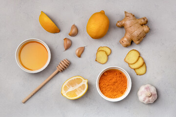 Turmeric, ginger, honey, garlic, lemon ingredients for making drinks. Folk remedies top view on gray background to prevent and treat colds, support the immune system and immune booster