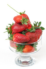 Group of fresh strawberries in the transparent vase, isolated on a white background