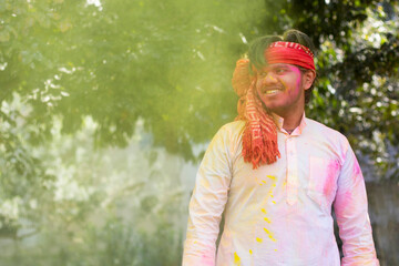 Young indian man celebrating holi color festival