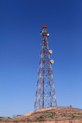 Cell phone and communication towers against blue sky