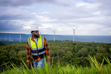 Portrait of engineer African American man working in wind turbine farm.