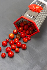 Red cherry tomatoes poured from a grater.