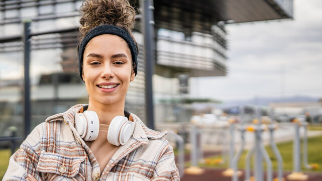 One young sporty woman with headphones happy smile stand outdoor