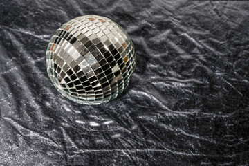 Mirror disco ball on black background. Brilliant decoration, silver decor. Party invitation concept. Copy space.