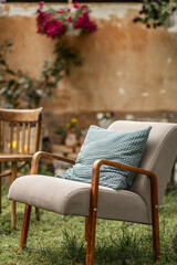 Fototapeta na wymiar a cozy place to relax with a retro-style armchair in the backyard of a country house on a sunny spring day
