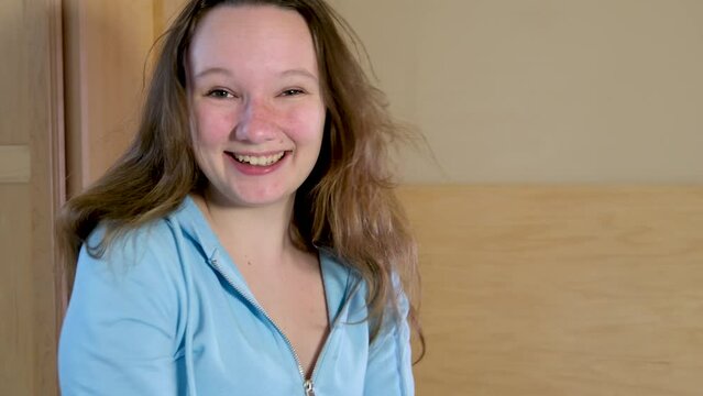 indescribable joy of teenager girl laughing with her mouth open jumping dancing on the bed in the room in the bedroom Cheerful teenager winning good news surprise joy fun