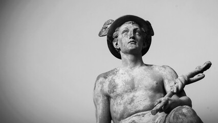 An ancient statue of antique god of commerce, business, merchants and travelers Hermes (Mercury). Copy space for text. Black and white image. - obrazy, fototapety, plakaty